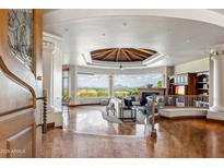 Inviting living room featuring a beamed ceiling, fireplace, built-ins, and stunning mountain views at 11988 E Larkspur Dr, Scottsdale, AZ 85259