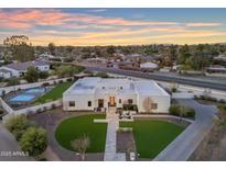 Stunning modern home with a minimalist design, manicured lawn and beautiful desert landscaping at sunset at 12034 N 61St St, Scottsdale, AZ 85254