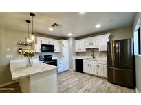 Charming kitchen featuring white cabinetry, stainless steel appliances, and marble countertops at 1803 W 6Th St, Mesa, AZ 85201