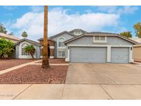 Charming gray two-story home featuring a three-car garage and manicured desert landscaping at 18860 N 73Rd Dr, Glendale, AZ 85308