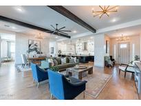 Open concept living room with wooden beams, modern lighting, and access to the dining and kitchen area at 25751 S 227Th Way, Queen Creek, AZ 85142