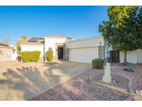 Charming single-story home with a two-car garage, desert landscaping, and a well-manicured lawn at 3019 E Redfield Rd, Phoenix, AZ 85032
