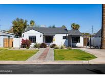 Charming home featuring a well-manicured lawn and a beautiful brick pathway to the front door at 406 W Coolidge St, Phoenix, AZ 85013