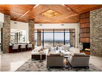 Open concept living area with stone columns, wood ceiling, fireplace and expansive views at 42690 N 98Th Pl, Scottsdale, AZ 85262
