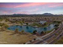 Beautiful aerial view showcasing the community lake, pool, and clubhouse with mountain views at 4769 E Thunderheart Trl # 101, Gilbert, AZ 85297