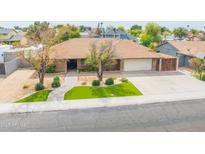 Charming single-story home featuring a manicured front yard, a two-car garage, and a welcoming walkway at 6409 W Riviera Dr, Glendale, AZ 85304