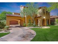 Stunning two-story stucco home featuring a portico, arched entryways, and lush landscaping at 9096 E Mountain Spring Rd, Scottsdale, AZ 85255