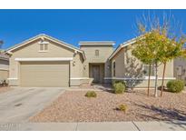 Charming single-story home features a well-maintained front yard with desert landscaping and a two-car garage at 21090 E Camina Buena Vis, Queen Creek, AZ 85142