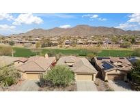 Stunning aerial view of desert homes, with a lush golf course nestled amidst rolling hills and blue skies at 2214 W Muirfield Dr, Anthem, AZ 85086