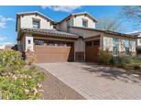 Beautiful two-story home featuring a three-car garage and desert landscaping at 2423 N Beverly Pl, Buckeye, AZ 85396