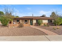Charming single-story home with desert landscaping, brick accents and covered porch with seating area at 3221 N 41St Pl, Phoenix, AZ 85018