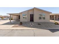 Charming home featuring a covered carport, well-maintained gravel landscaping, and a decorative wreath on the front door at 3301 S Goldfield Rd # 2034, Apache Junction, AZ 85119