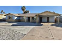 Charming single-story home featuring light blue paint, covered carport, desert landscaping, and a spacious driveway at 4231 E Roeser Rd, Phoenix, AZ 85040