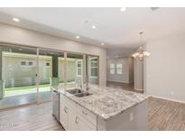 Bright kitchen boasts a granite island, stainless steel appliances, and sliding doors to the outdoor space at 4444 E Bethena St, Gilbert, AZ 85295