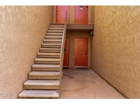 Exterior view of a multi-story residential building with staircases leading to upper-level units and entry doors at 5525 E Thomas Rd # K6, Phoenix, AZ 85018