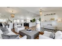 Open-concept living space with stylish decor, hardwood floors, and seamless flow to kitchen and dining areas at 6527 W Bloomfield Rd, Glendale, AZ 85304