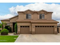 Lovely two-story home featuring a three-car garage and desert landscaping at 6963 W Aurora Dr, Glendale, AZ 85308