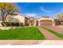 Stunning home featuring lush lawn, mature trees, an arched entry, and a spacious three-car garage at 9834 E Voltaire Dr, Scottsdale, AZ 85260