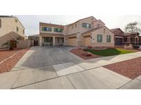 Charming two-story home featuring a spacious driveway, three-car garage, and low-maintenance landscaping with decorative rocks and turf at 17687 W Surrey Dr, Surprise, AZ 85388