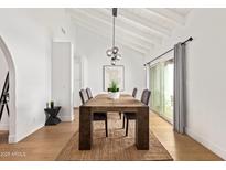 Bright dining room featuring a wooden table, modern lighting, and sliding doors to outdoor area at 2629 S Country Club Way, Tempe, AZ 85282