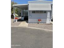 Charming single-story home featuring awnings, a covered porch, and inviting red flowerpots for enhanced curb appeal at 2650 W Union Hills Dr # 272, Phoenix, AZ 85027