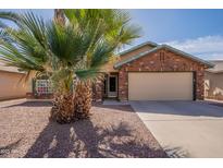 Charming brick home featuring desert landscaping, a two-car garage and mature palm trees in front yard at 4873 E Magnus Dr, San Tan Valley, AZ 85140