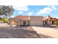 Charming single-story home featuring a red tile roof, desert landscaping and attached two-car garage at 7109 W Julie Dr, Glendale, AZ 85308