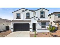 Charming white two-story home featuring a black two car garage and well-manicured landscaping at 7449 W Buckhorn Trl, Peoria, AZ 85383