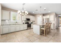 Spacious kitchen with stainless steel appliances, granite countertops, and a large island with seating at 9144 W Surrey Dr, Peoria, AZ 85381