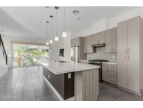 Modern kitchen with a large island, stainless steel appliances, and gray cabinets at 1717 E Morten Ave # 7, Phoenix, AZ 85020