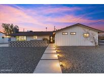 Charming home featuring modern walkway lighting and decorative block wall, set against a vibrant sky at 1744 E Luke Ave, Phoenix, AZ 85016