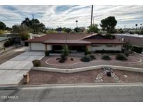 Charming single-story home with a well-maintained front yard and a spacious driveway at 5241 N Woodmere Fairway --, Scottsdale, AZ 85250