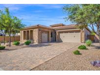 Charming single-story home featuring a stone facade, paver driveway, and well-manicured landscaping at 5446 S Sandstone Ct, Gilbert, AZ 85298