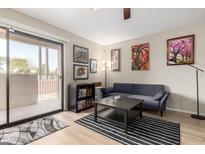 Bright living room features a sliding glass door to a balcony and stylish decor at 715 S Extension Rd # 70, Mesa, AZ 85210