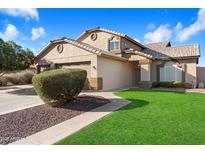 Charming home with manicured lawn, mature shrubbery, and a three-car garage at 7648 W Betty Elyse Ln, Peoria, AZ 85382