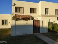 Inviting two-story townhouse showcasing a private gated entrance and stucco facade at 7917 E Keim Dr, Scottsdale, AZ 85250