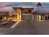 Charming two-story home featuring a spacious three-car garage and well-maintained landscaping at dusk at 826 W Royal Palms Dr, Gilbert, AZ 85233