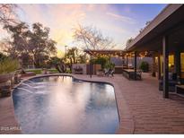 Inviting backyard pool featuring a bar, dining, and lounge area, perfect for outdoor entertaining at 8433 E Cholla St, Scottsdale, AZ 85260