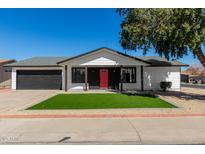 Charming single-story home featuring a well-manicured front yard and a striking red front door at 8602 W Clarendon Ave, Phoenix, AZ 85037