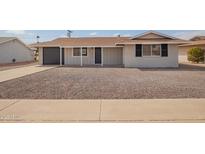 Charming single-story home featuring neutral paint, black shutters, a gravel yard and a convenient attached garage at 12414 N Pebble Beach Dr, Sun City, AZ 85351