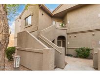 Exterior view of a two-story townhome with neutral stucco and an outdoor entryway leading to the unit's front door at 15225 N 100Th St # 2210, Scottsdale, AZ 85260