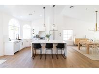 Bright, open kitchen with a large center island, sleek white cabinets, and stainless steel appliances at 18864 N 92Nd Way, Scottsdale, AZ 85255