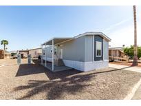 Charming mobile home featuring a covered entrance, neutral paint scheme, and low-maintenance gravel landscaping at 2650 W Union Hills Dr # 123, Phoenix, AZ 85027