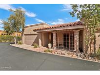 Charming southwestern home featuring a red tile roof, desert landscaping, and a two car garage at 37300 N Tom Darlington Dr # J, Carefree, AZ 85377