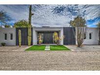Stunning modern home with desert landscaping, black doors, and artificial grass at 12209 N 66Th St, Scottsdale, AZ 85254