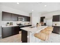 Stylish kitchen featuring dark cabinets, stainless appliances, and a large island with bar stools at 1331 S Vista Ave, Florence, AZ 85132