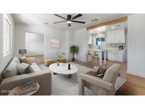 Bright living room with modern decor open to a beautiful white kitchen with bar seating at 1642 E Turney Ave, Phoenix, AZ 85016