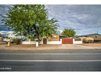 The house has a red metal gate and desert landscaping surrounding the property at 17841 N 20Th St, Phoenix, AZ 85022