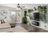 Cozy living room featuring a ceiling fan, diamond-paned window, and sleek hardwood floors at 1920 W Lindner W Ave # 277, Mesa, AZ 85202
