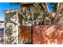 Inviting two-story condo with a charming wooden gate and brick wall accenting the property at 2301 E University Dr # 486, Mesa, AZ 85213